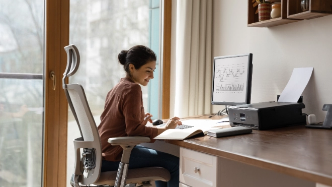 woman behind desk working on a computer